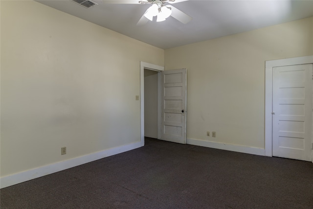 unfurnished room with dark colored carpet and ceiling fan