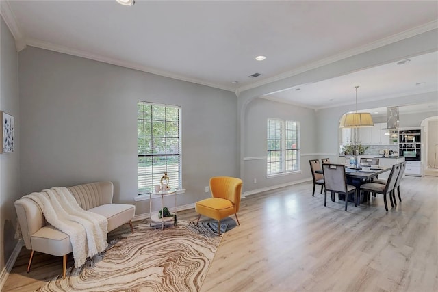 sitting room with light wood-type flooring and ornamental molding