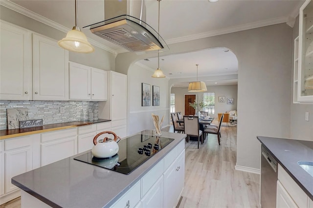 kitchen with white cabinets, black electric stovetop, crown molding, decorative light fixtures, and light hardwood / wood-style floors