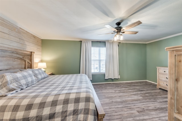 unfurnished bedroom featuring ceiling fan, crown molding, and light hardwood / wood-style floors