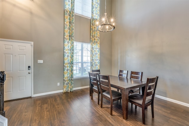 dining area featuring a chandelier, a high ceiling, and dark hardwood / wood-style floors