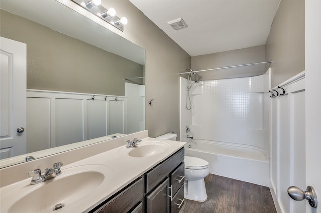 full bathroom with hardwood / wood-style floors, vanity,  shower combination, and toilet