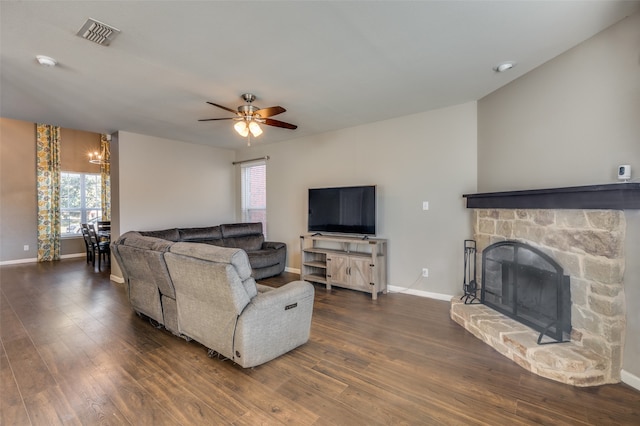 living room featuring a fireplace, a healthy amount of sunlight, dark wood-type flooring, and ceiling fan with notable chandelier