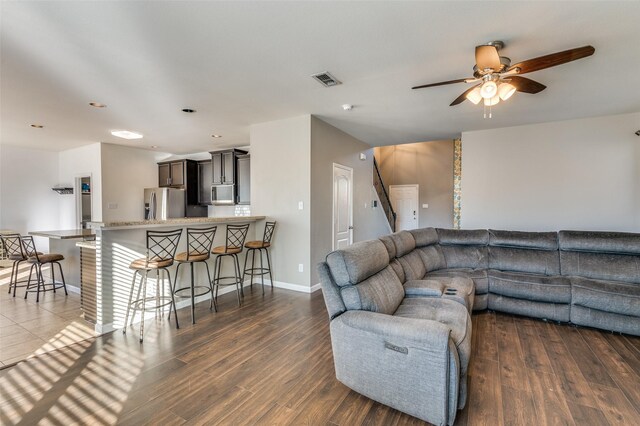 living room featuring ceiling fan and dark hardwood / wood-style flooring