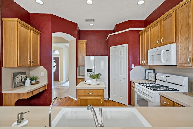 kitchen with sink, white appliances, a textured ceiling, and light tile patterned floors