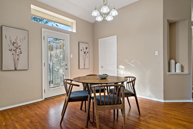 dining area featuring wood-type flooring and an inviting chandelier