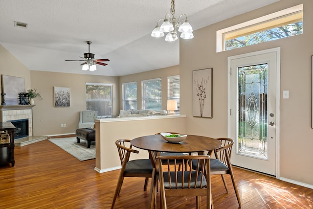 dining space featuring wood-type flooring, lofted ceiling, and a healthy amount of sunlight