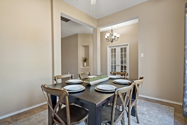 dining space featuring ceiling fan with notable chandelier and french doors