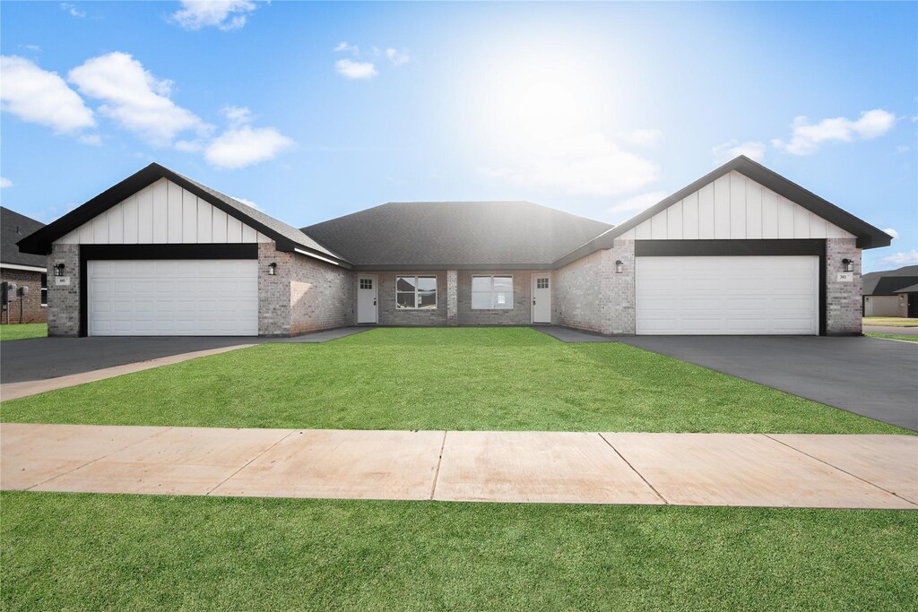 view of front of property with a garage and a front lawn