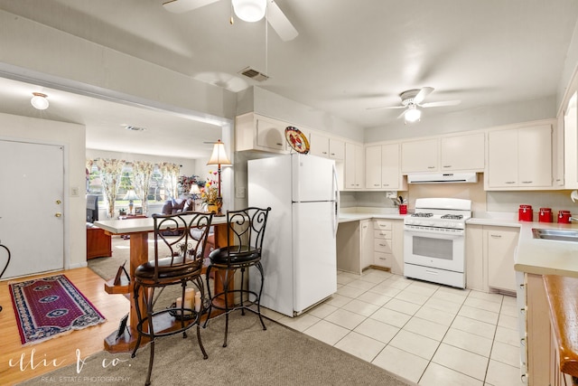 kitchen with light wood-type flooring, white appliances, white cabinetry, and sink