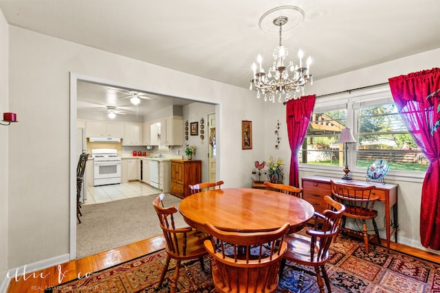 dining room with ceiling fan with notable chandelier and light hardwood / wood-style flooring