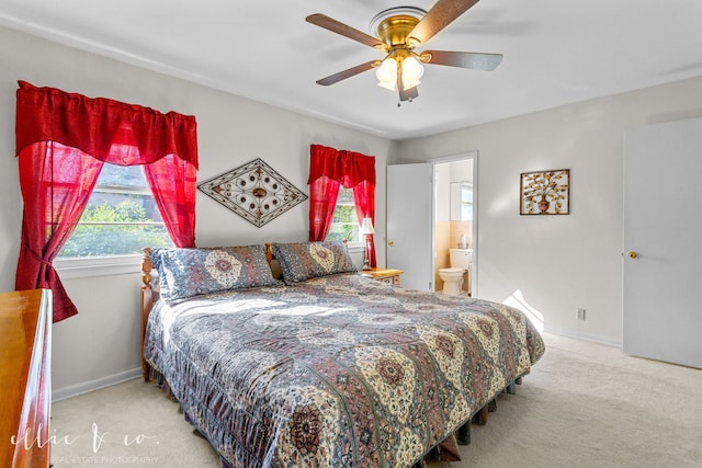 bedroom featuring ensuite bathroom, ceiling fan, and light colored carpet