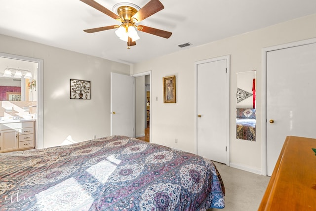 carpeted bedroom with connected bathroom, ceiling fan, and two closets