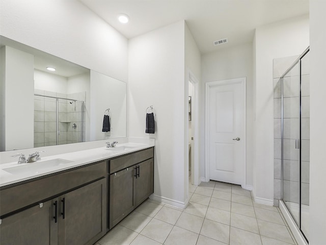 bathroom with tile patterned flooring, vanity, and walk in shower