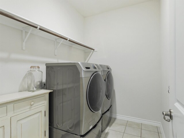 laundry room featuring washing machine and clothes dryer and light tile patterned floors