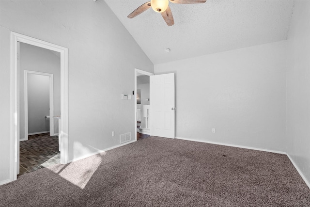 unfurnished bedroom with dark colored carpet, ceiling fan, a textured ceiling, and vaulted ceiling