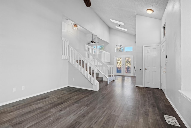 foyer entrance with ceiling fan, french doors, high vaulted ceiling, dark hardwood / wood-style floors, and a textured ceiling