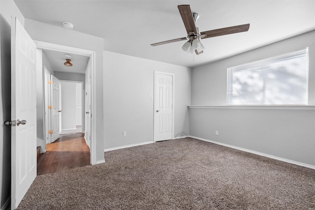 unfurnished bedroom featuring ceiling fan and dark carpet