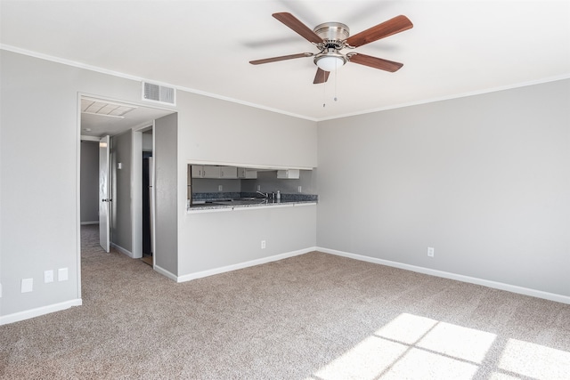 unfurnished living room featuring carpet floors, ceiling fan, ornamental molding, and sink