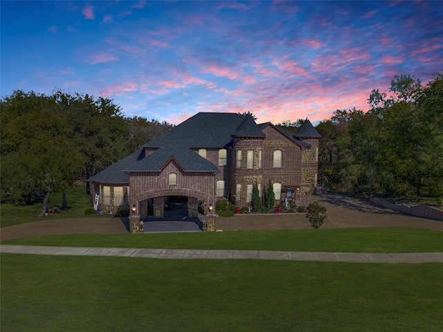 view of front of property featuring stone siding, brick siding, and a yard