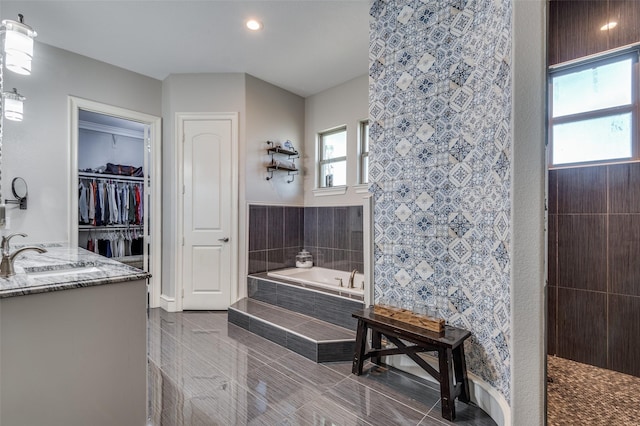 bathroom with tile patterned flooring, vanity, separate shower and tub, and tile walls