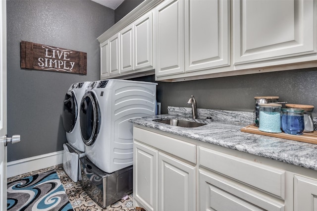 washroom featuring cabinets, sink, and washing machine and clothes dryer