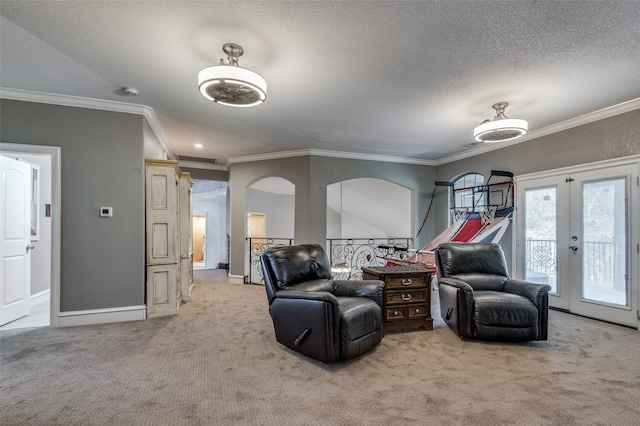 living area featuring a textured ceiling, carpet floors, crown molding, and french doors