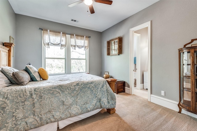 bedroom featuring connected bathroom, light colored carpet, and ceiling fan