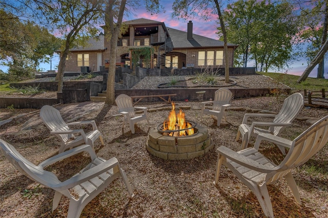 back house at dusk with an outdoor fire pit