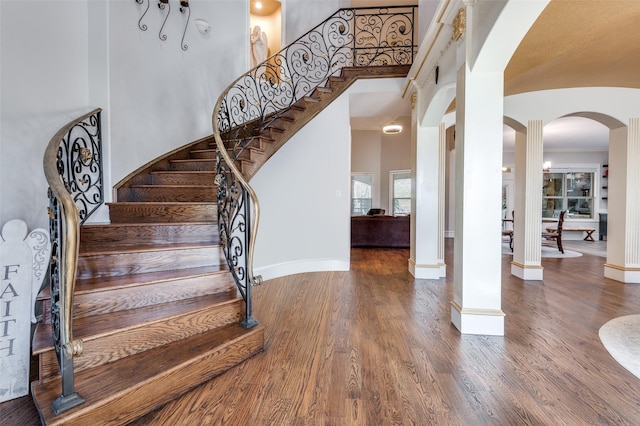 stairs with a high ceiling and hardwood / wood-style floors