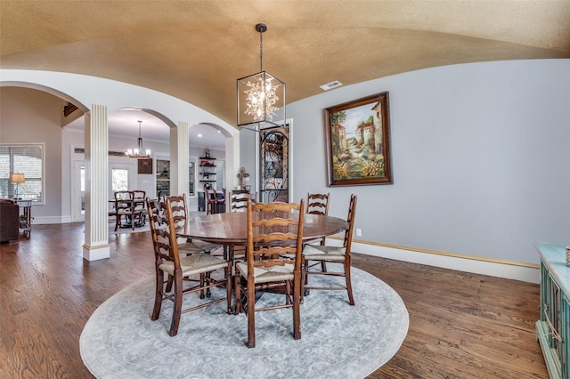 dining room with dark hardwood / wood-style flooring, vaulted ceiling, and a notable chandelier