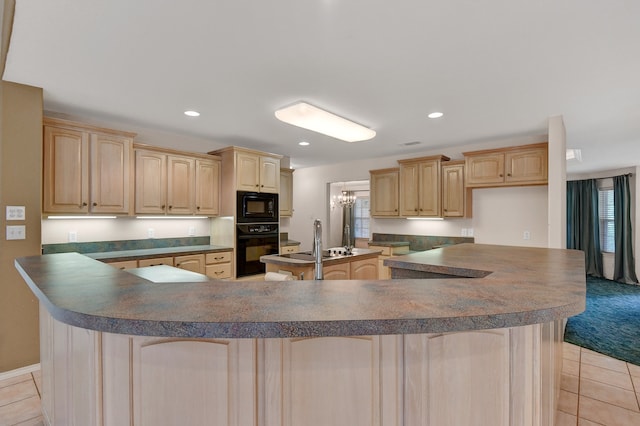 kitchen featuring light brown cabinets, black appliances, light tile patterned floors, a notable chandelier, and a kitchen island