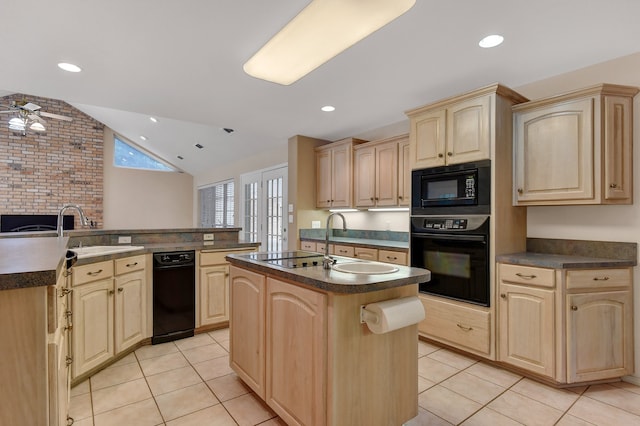 kitchen featuring kitchen peninsula, light brown cabinetry, black appliances, a center island, and lofted ceiling