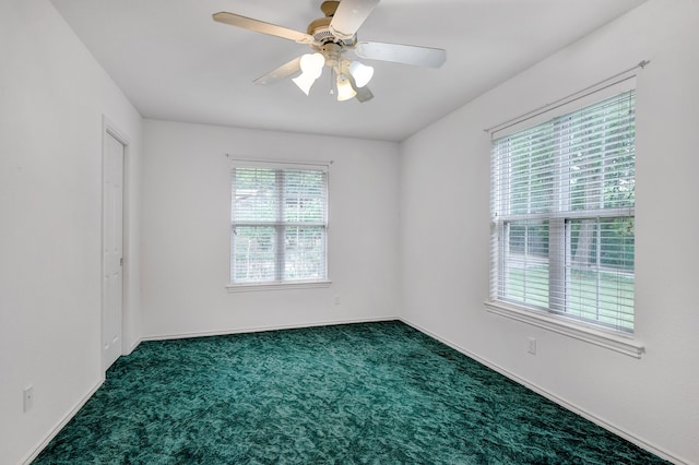 unfurnished room featuring ceiling fan and dark colored carpet