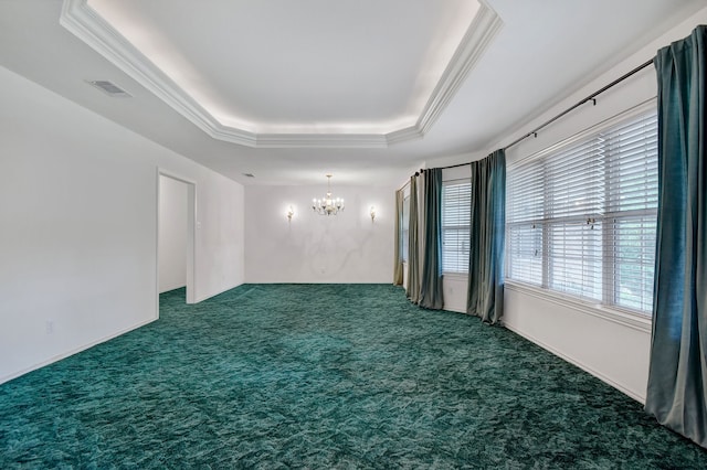 spare room with dark colored carpet, a chandelier, a raised ceiling, and crown molding