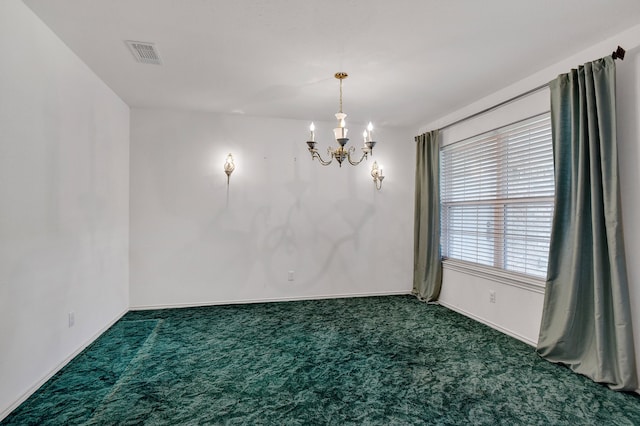 carpeted empty room with a notable chandelier