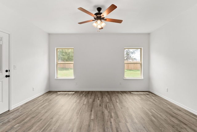 spare room featuring ceiling fan, plenty of natural light, and light hardwood / wood-style floors