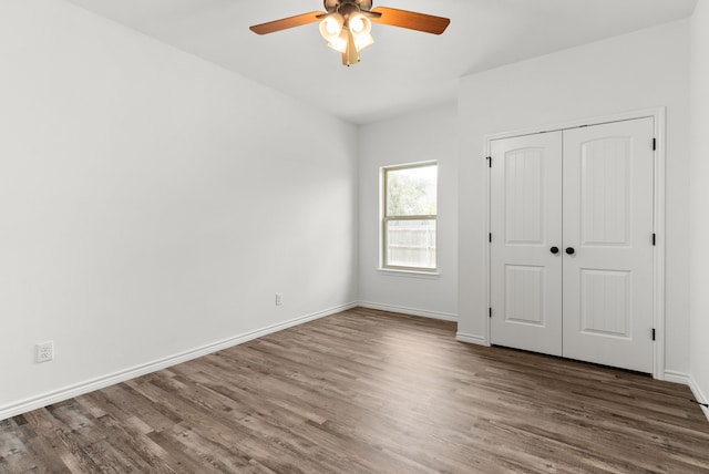 unfurnished bedroom with ceiling fan, a closet, and dark hardwood / wood-style floors