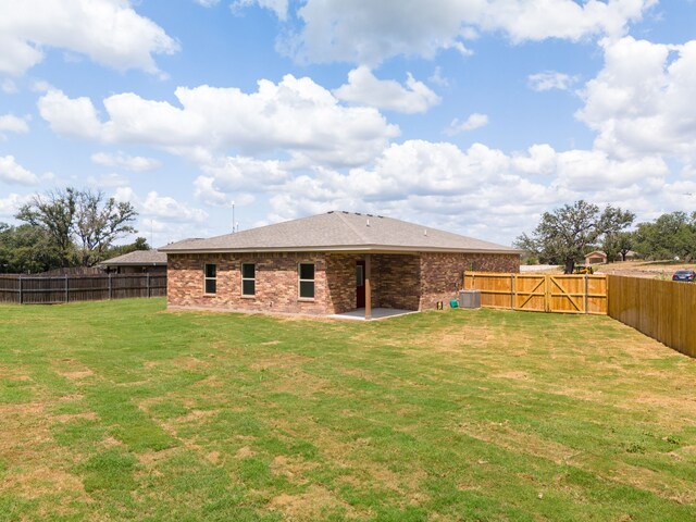 back of property featuring cooling unit and a yard