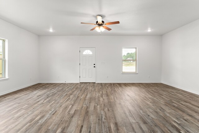 unfurnished living room with ceiling fan and hardwood / wood-style floors