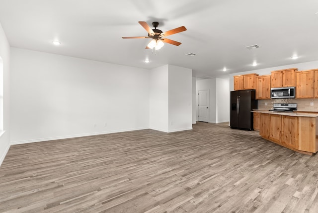 kitchen featuring tasteful backsplash, ceiling fan, light hardwood / wood-style flooring, and stainless steel appliances