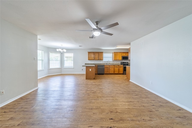 kitchen featuring sink, decorative light fixtures, light wood-type flooring, stainless steel appliances, and ceiling fan with notable chandelier