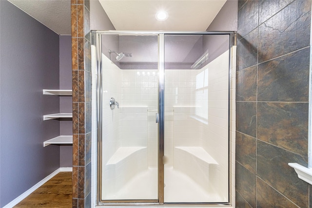 bathroom featuring hardwood / wood-style flooring and walk in shower