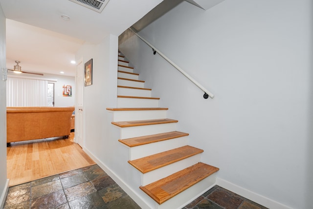 stairway with hardwood / wood-style floors and ceiling fan