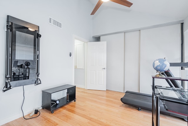 workout room with ceiling fan, high vaulted ceiling, and hardwood / wood-style flooring