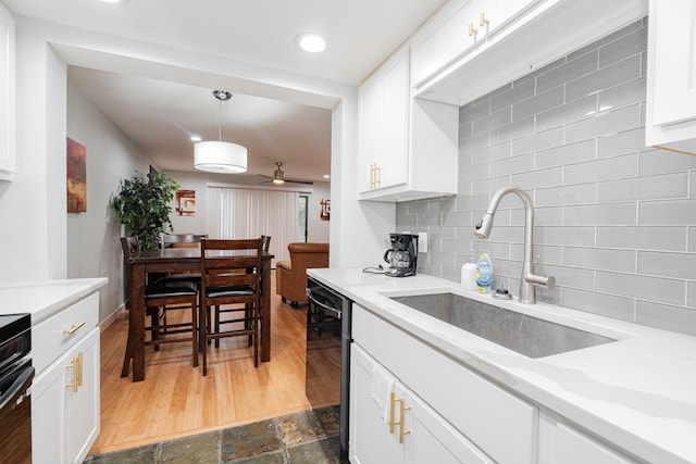 kitchen featuring tasteful backsplash, white cabinetry, sink, and pendant lighting