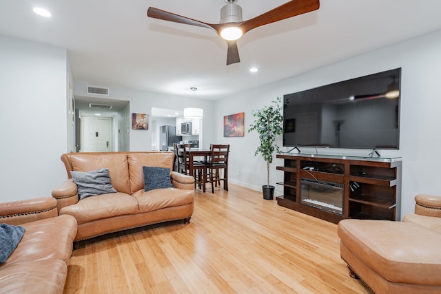 living room featuring hardwood / wood-style flooring and ceiling fan