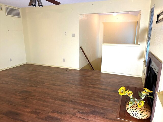 unfurnished living room featuring dark hardwood / wood-style floors and ceiling fan