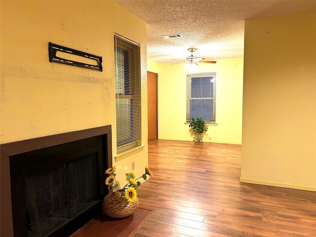 living room with wood-type flooring, a textured ceiling, and ceiling fan