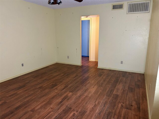 spare room featuring a textured ceiling, ceiling fan, and dark wood-type flooring